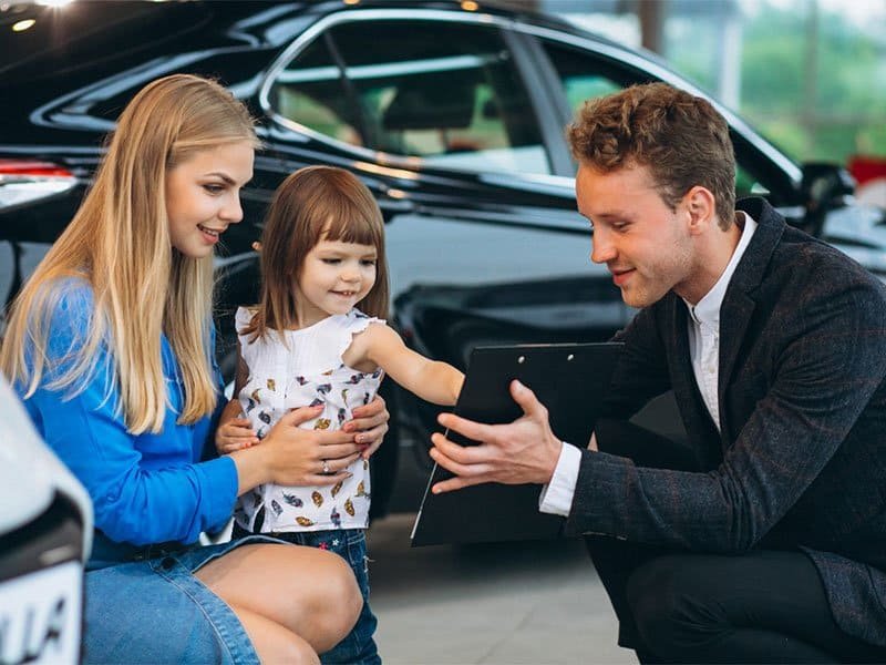 Agent helping mother and daughter – compare auto insurance quotes